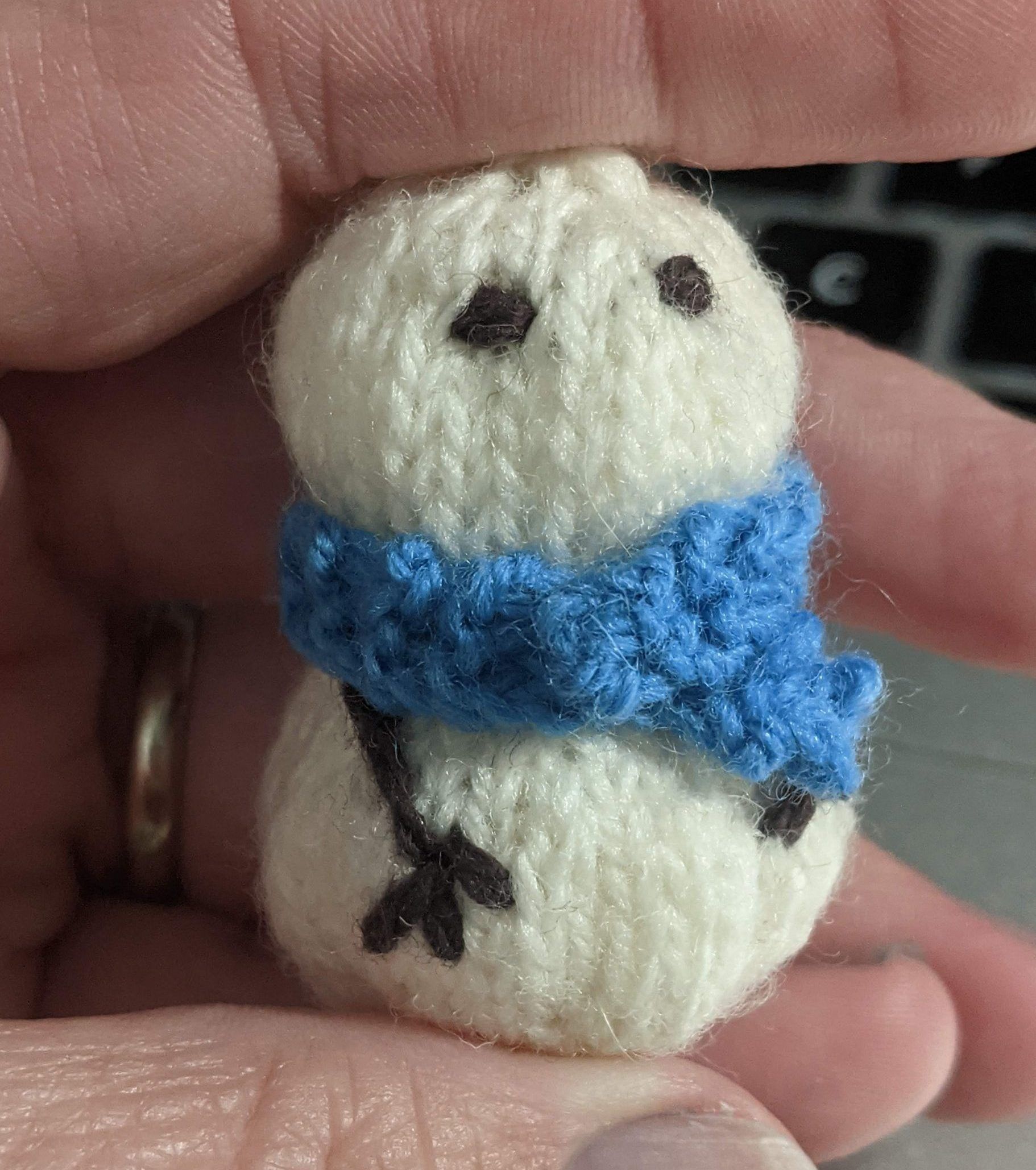 Image is of a small knitted toy snowman.
